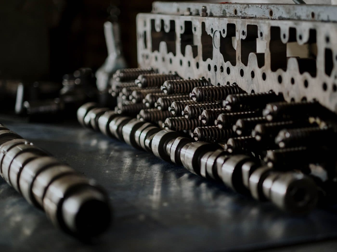 Camshafts and a cylinder head with valve springs lined up on the bench