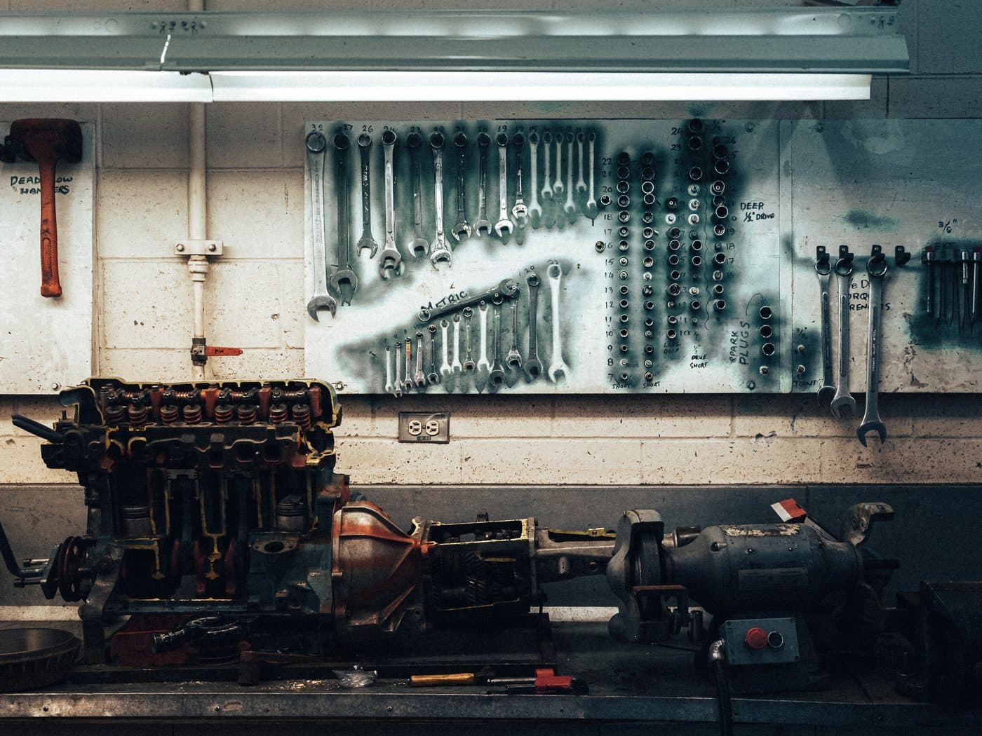 An engine block on the bench with tools racked behind it