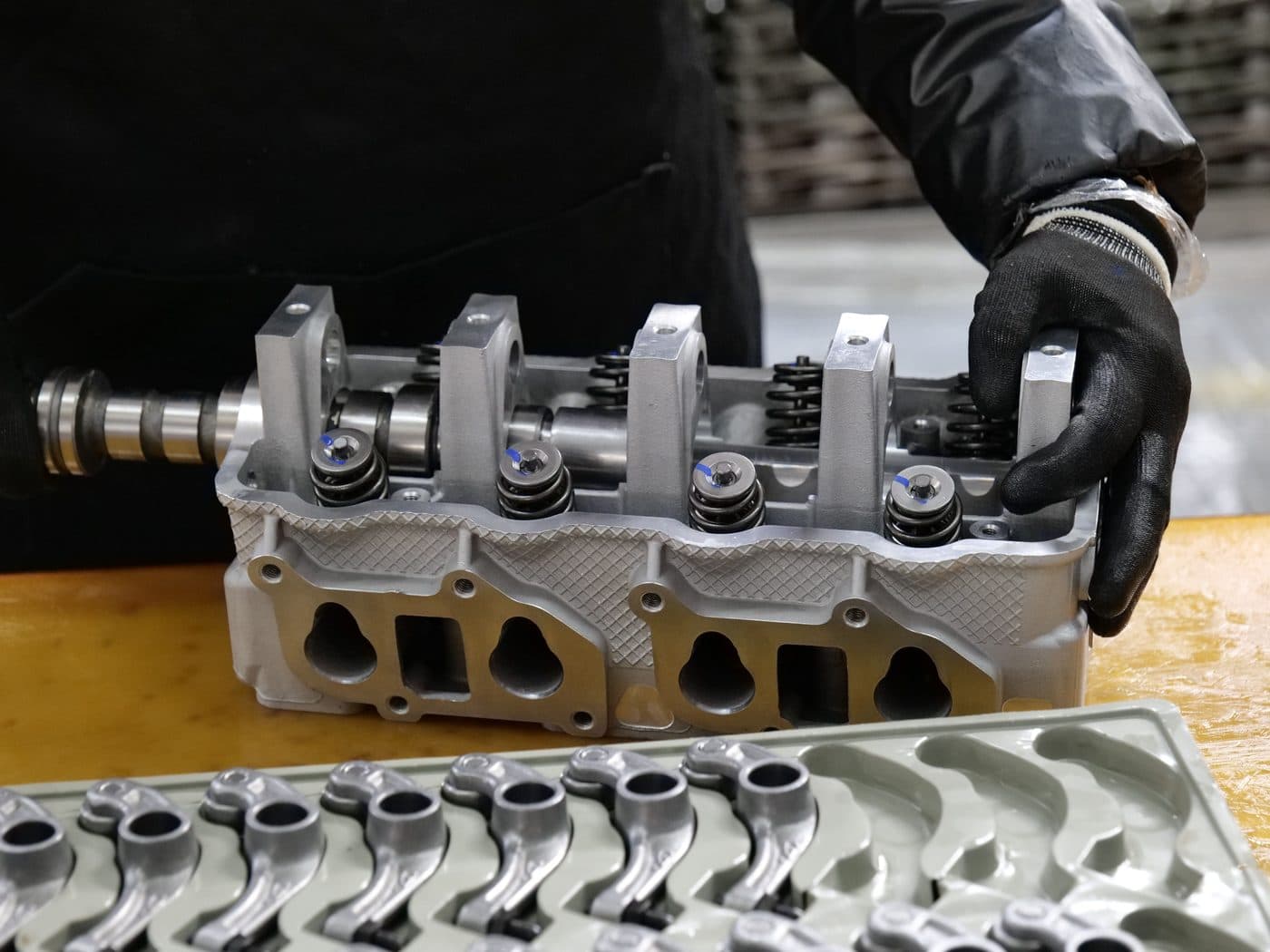 A machinist assembling valvetrain components by hand
